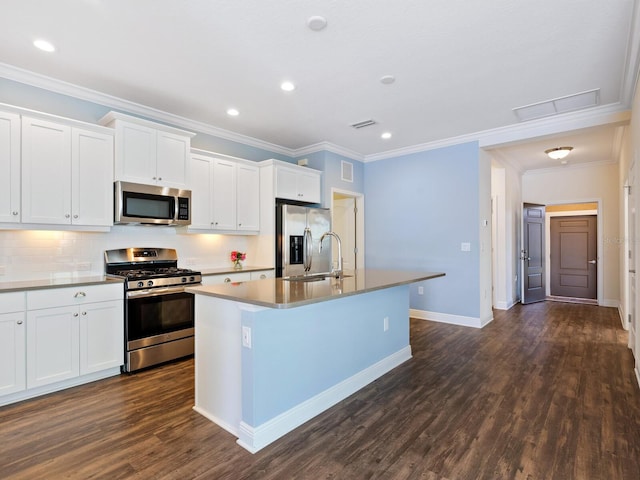 kitchen with white cabinets, appliances with stainless steel finishes, dark hardwood / wood-style flooring, tasteful backsplash, and a kitchen island with sink