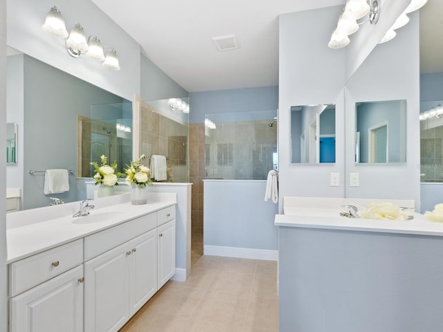 bathroom featuring tile patterned floors, vanity, and a tile shower