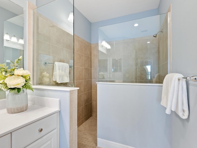 bathroom with tiled shower and vanity