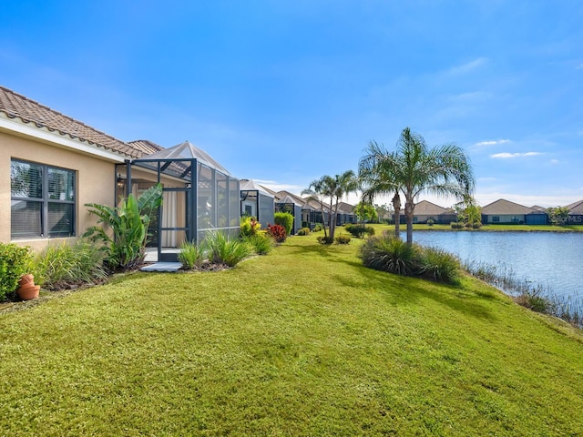 view of yard featuring a lanai and a water view