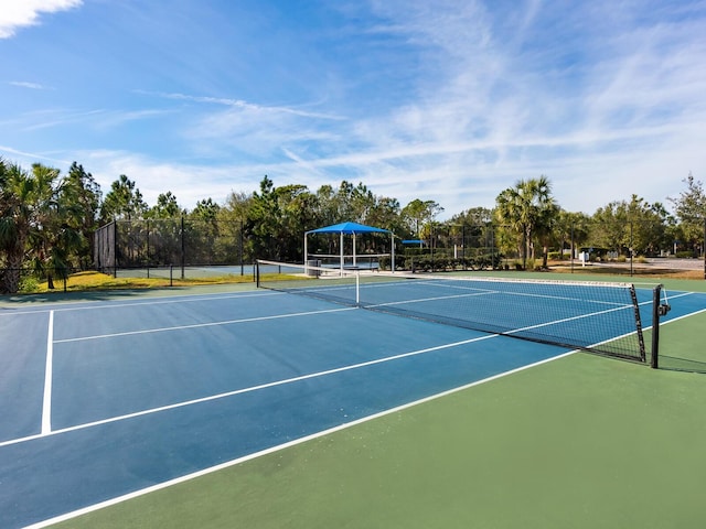 view of tennis court featuring basketball hoop