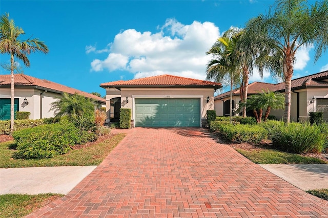 2572 Daisy Dr, North Port, FL 34289 - mediterranean / spanish-style home featuring stucco siding, decorative driveway, an attached garage, and a tiled roof