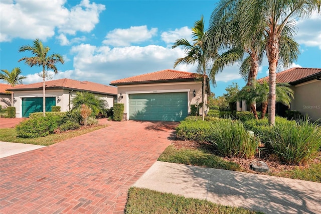 2572 Daisy Dr, North Port, FL 34289 - mediterranean / spanish home with stucco siding, decorative driveway, a garage, and a tiled roof