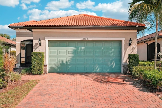 2572 Daisy Dr, North Port, FL 34289 - view of front of home featuring decorative driveway, a garage, stucco siding, and a tiled roof