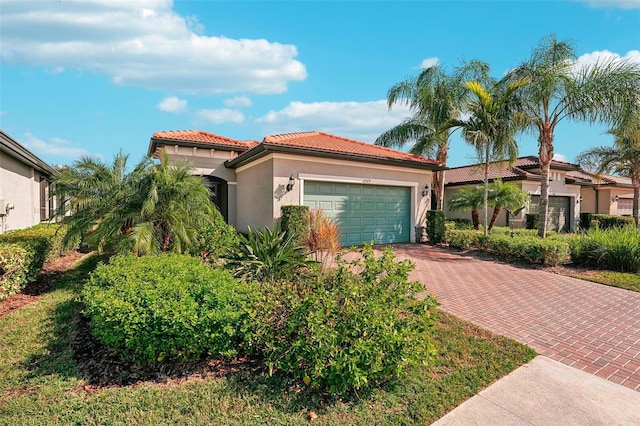 2572 Daisy Dr, North Port, FL 34289 - mediterranean / spanish home featuring stucco siding, decorative driveway, a garage, and a tile roof
