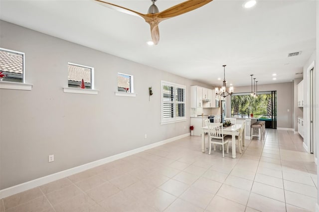 dining room featuring a notable chandelier, a healthy amount of sunlight, light tile patterned floors, and sink