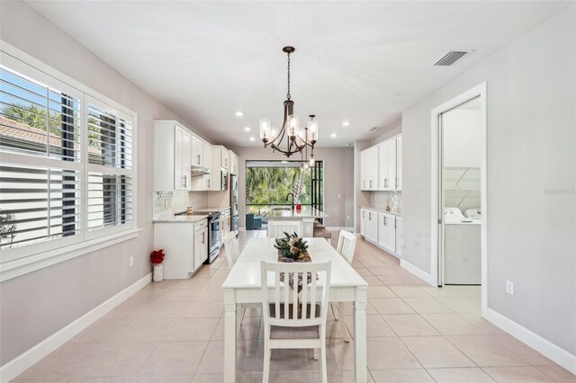 2572 Daisy Dr, North Port, FL 34289 - dining room featuring washing machine and clothes dryer, a chandelier, light tile patterned floors, and recessed lighting