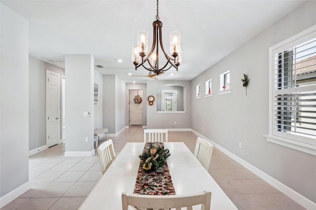 dining space featuring light tile patterned flooring and a notable chandelier