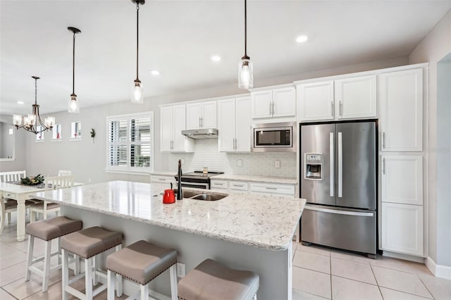 kitchen featuring sink, an island with sink, decorative light fixtures, white cabinets, and appliances with stainless steel finishes