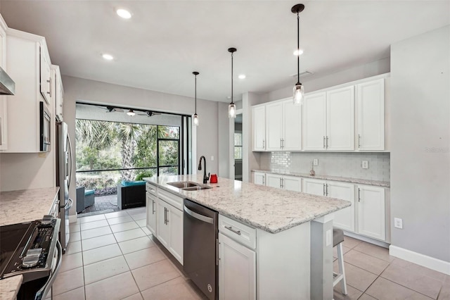 kitchen with white cabinets, decorative light fixtures, an island with sink, and appliances with stainless steel finishes