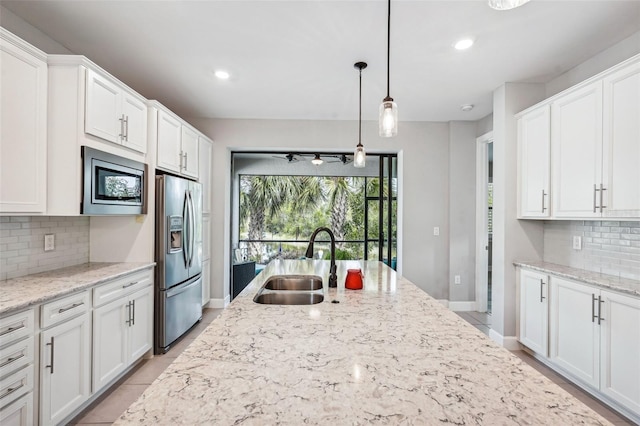 2572 Daisy Dr, North Port, FL 34289 - kitchen with stainless steel appliances, tasteful backsplash, white cabinets, recessed lighting, and hanging light fixtures