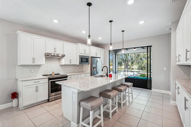 kitchen featuring white cabinets, sink, stainless steel appliances, and a kitchen island with sink