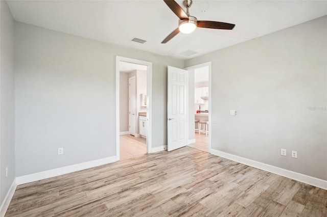 unfurnished bedroom with ensuite bath, ceiling fan, and light wood-type flooring