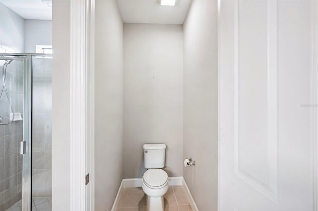 bathroom featuring tile patterned flooring, toilet, and walk in shower