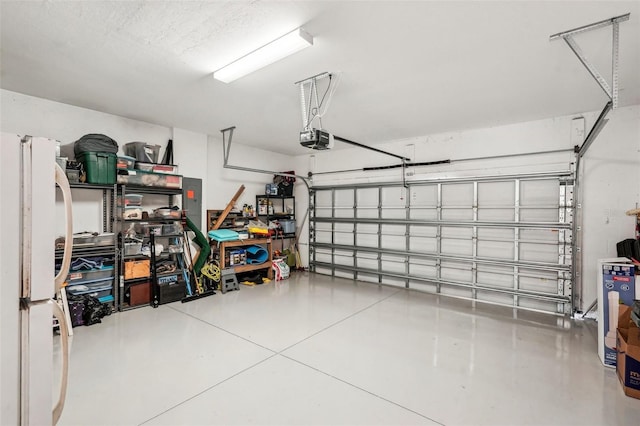 garage with white fridge and a garage door opener