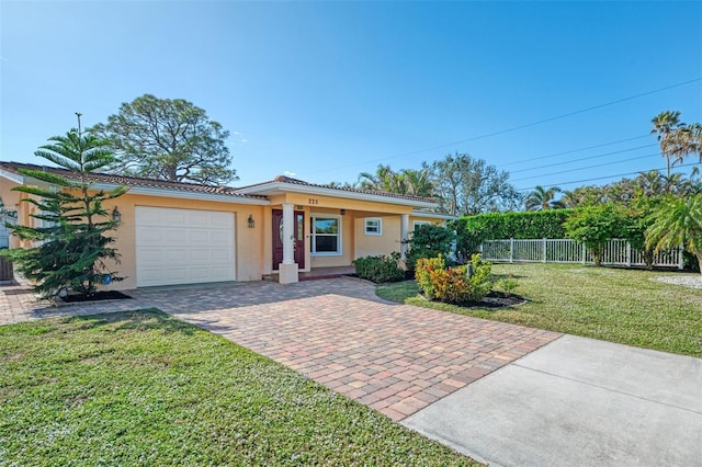 single story home with a garage and a front lawn