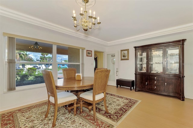 dining space with light wood-type flooring, ornamental molding, and a chandelier