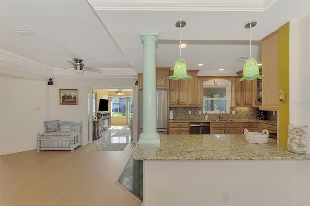 kitchen with backsplash, sink, kitchen peninsula, stainless steel appliances, and decorative columns