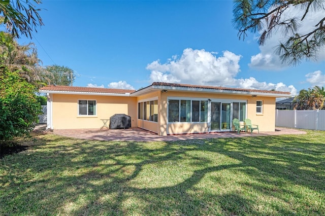 rear view of house with a patio area and a lawn