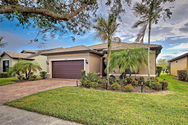 mediterranean / spanish-style home featuring a front lawn and a garage