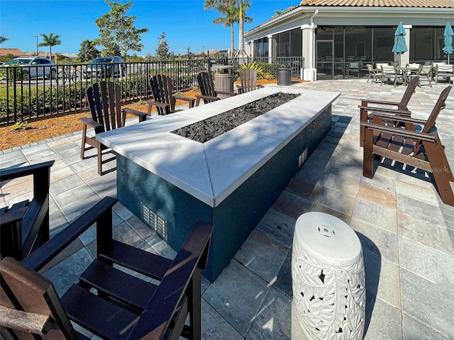 view of patio featuring a fire pit and a sunroom