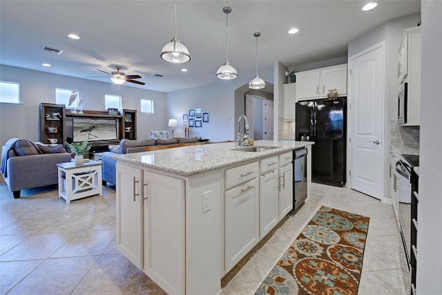 kitchen with ceiling fan, decorative light fixtures, a center island with sink, black appliances, and white cabinets