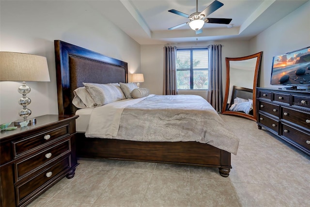 bedroom with a raised ceiling and ceiling fan