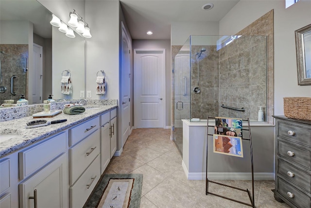 bathroom with a shower with shower door, vanity, and tile patterned floors