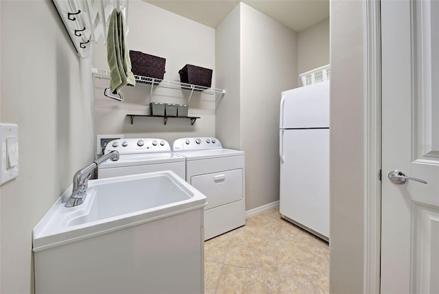 washroom with sink, light tile patterned floors, and washing machine and clothes dryer