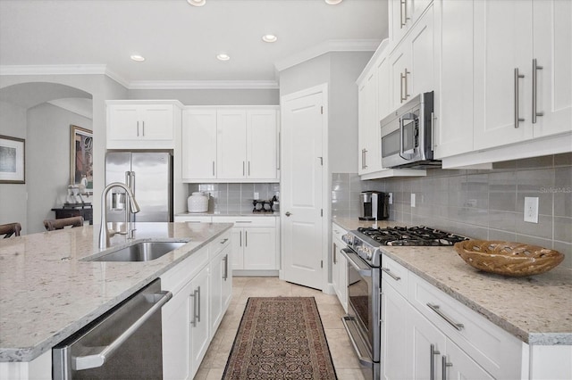 kitchen featuring tasteful backsplash, sink, white cabinets, and appliances with stainless steel finishes