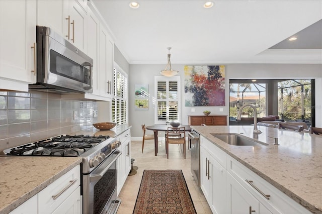 kitchen featuring white cabinets, light stone counters, sink, and appliances with stainless steel finishes