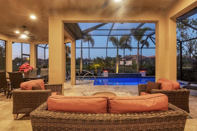 pool at dusk with an outdoor living space, pool water feature, ceiling fan, glass enclosure, and a patio area