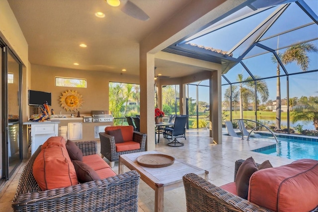 view of patio / terrace featuring area for grilling, an outdoor living space, ceiling fan, exterior kitchen, and glass enclosure