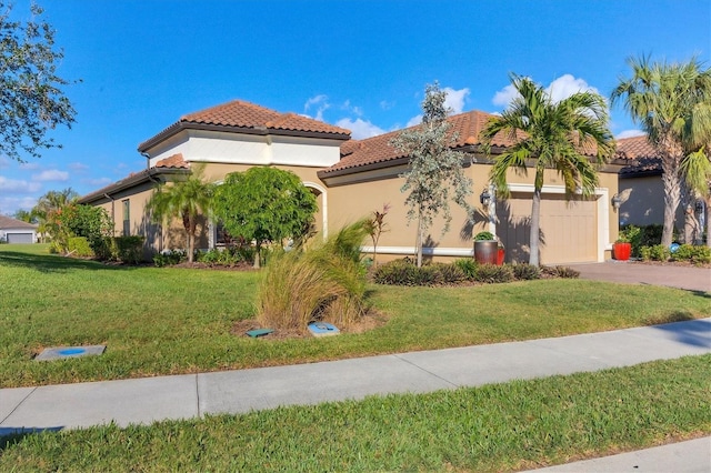 mediterranean / spanish-style house featuring a front lawn, an attached garage, a tiled roof, and aphalt driveway