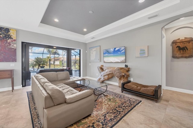 living room with ornamental molding, baseboards, arched walkways, and a raised ceiling