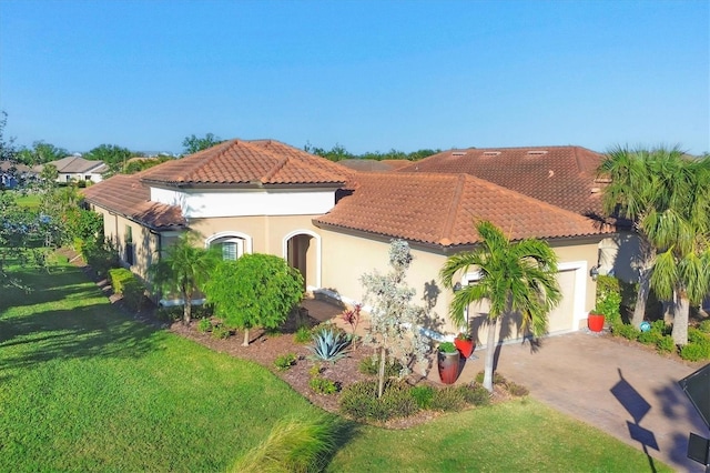 mediterranean / spanish-style house featuring a tile roof, driveway, an attached garage, a front yard, and stucco siding