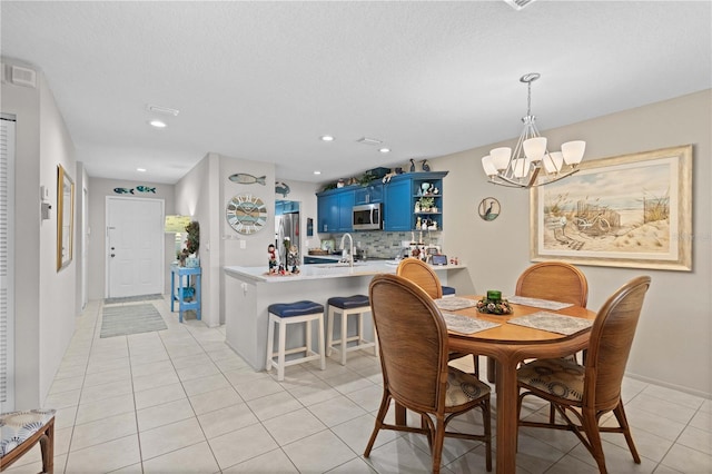 dining area featuring sink, a textured ceiling, a notable chandelier, and light tile patterned flooring