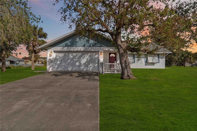 ranch-style house featuring a lawn and a garage