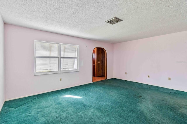 carpeted spare room featuring a textured ceiling