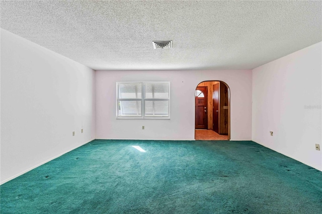 spare room with a textured ceiling and carpet floors