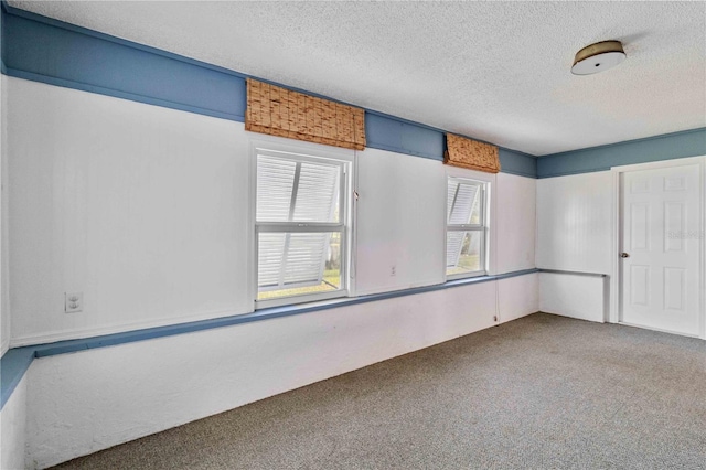 empty room featuring carpet and a textured ceiling