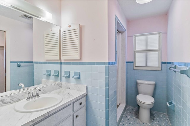 bathroom featuring tile patterned floors, vanity, tile walls, and toilet