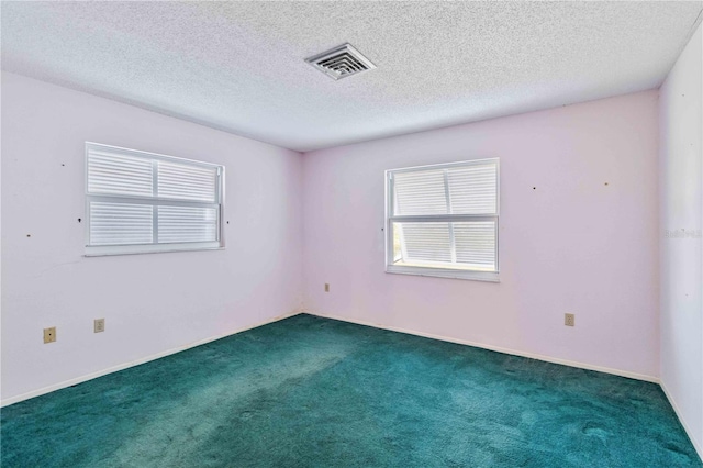 carpeted spare room with a textured ceiling