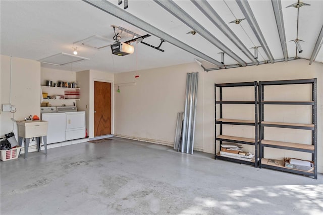 garage featuring separate washer and dryer, a garage door opener, and sink