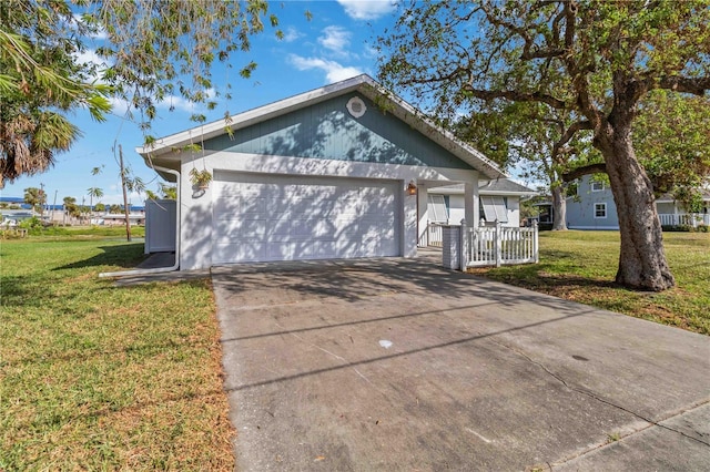 view of front of home featuring covered porch, a garage, and a front lawn