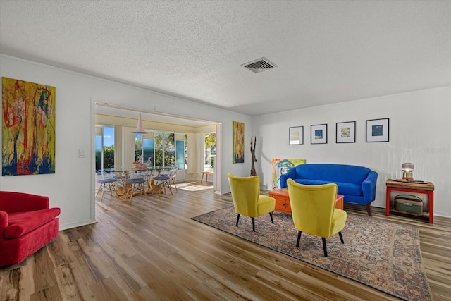 sitting room with wood-type flooring and a textured ceiling