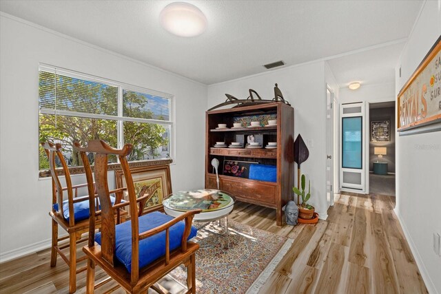 dining area with hardwood / wood-style flooring and crown molding