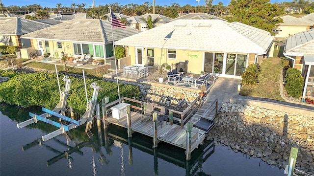 back of property with a patio area and a water view