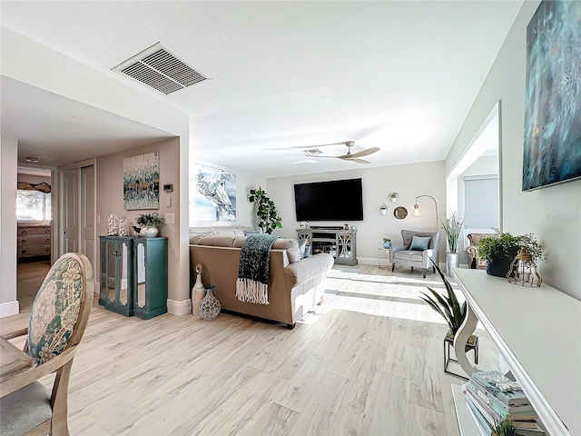 living room featuring light hardwood / wood-style flooring and ceiling fan