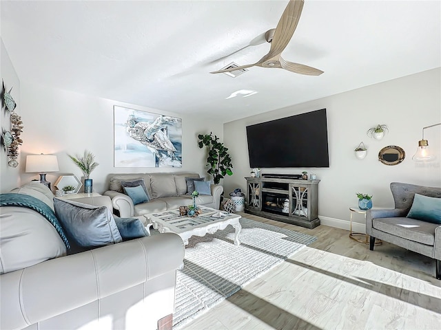 living room with ceiling fan and light hardwood / wood-style flooring